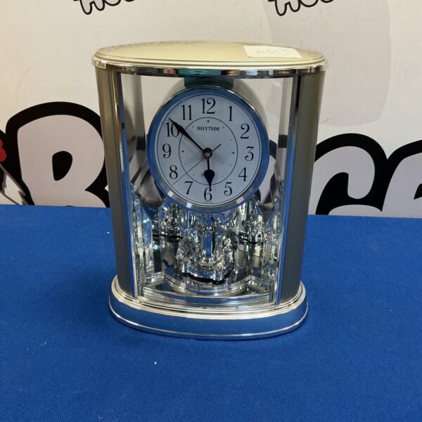 Modern chrome mantle clock with clear face and quartz movement.