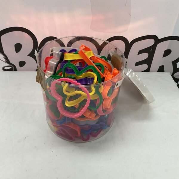 Colourful plastic cookie cutters in a clear storage tub.