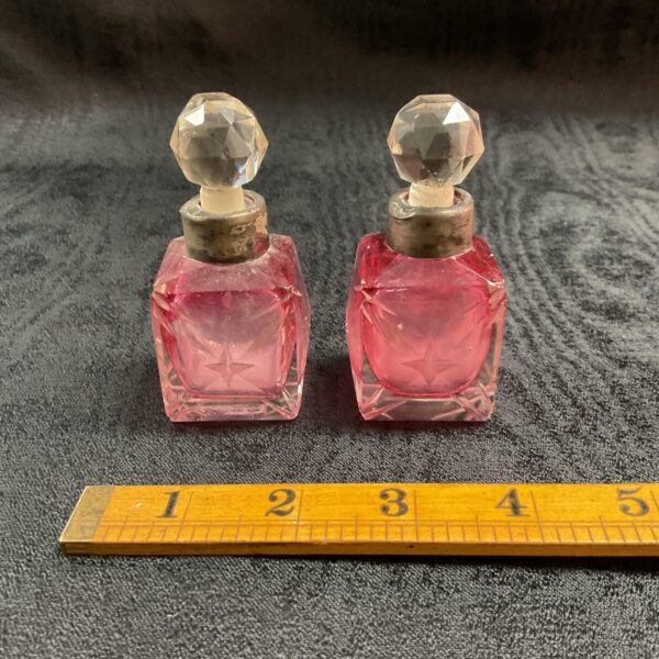 Antique cranberry glass scent bottles with silver mounts.