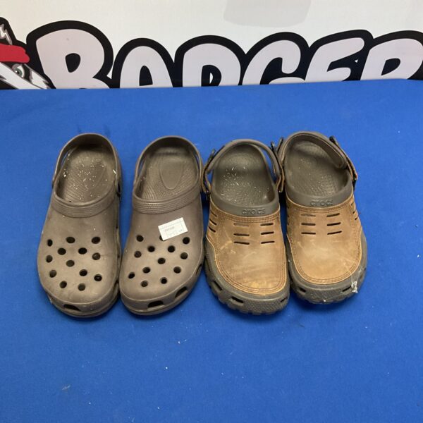 Two pairs of Crocs clogs in sizes 10 and 12, showing wear.