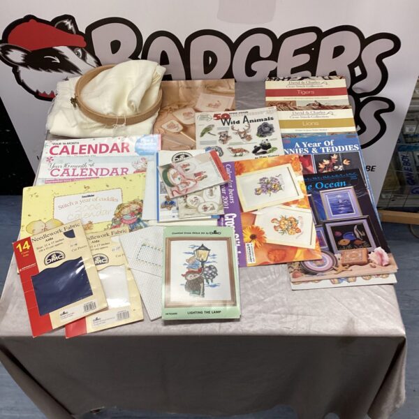 Vintage cross stitch magazines and fabric scraps for crafting projects.