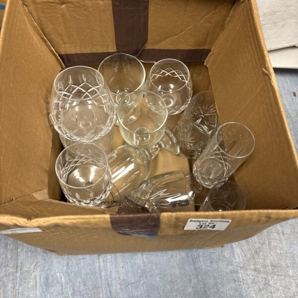Collection of vintage crystal cut glassware in a cardboard box.
