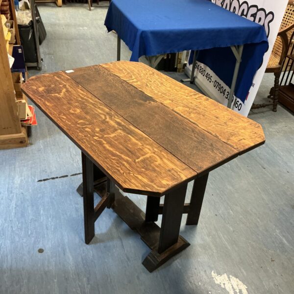 Rustic dark oak folding table in a home setting.