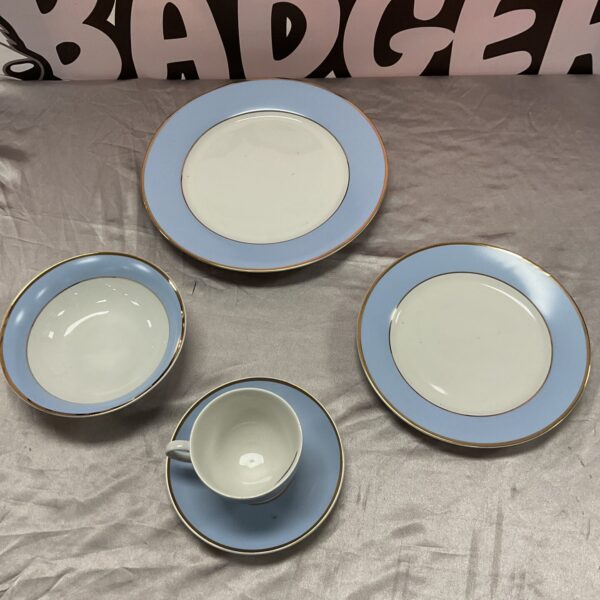 Vintage Doulton dinner set with plates and cups on display.