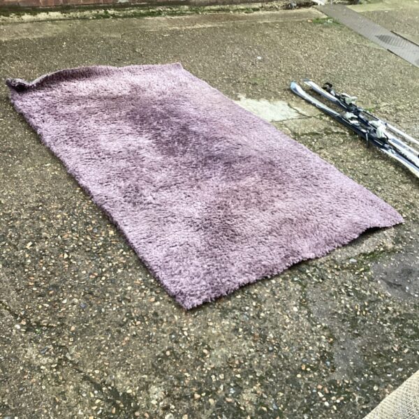 Purple shaggy Dunelm rug for living room comfort.