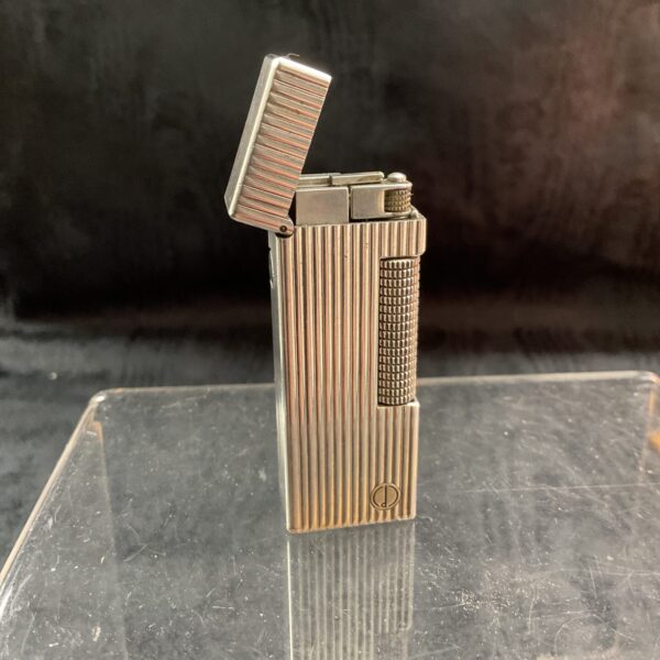 Vintage Dunhill Rollalite gas lighter in silver tone, side view.