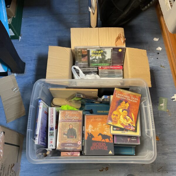 Mixed lot of DVDs and CDs for home entertainment.