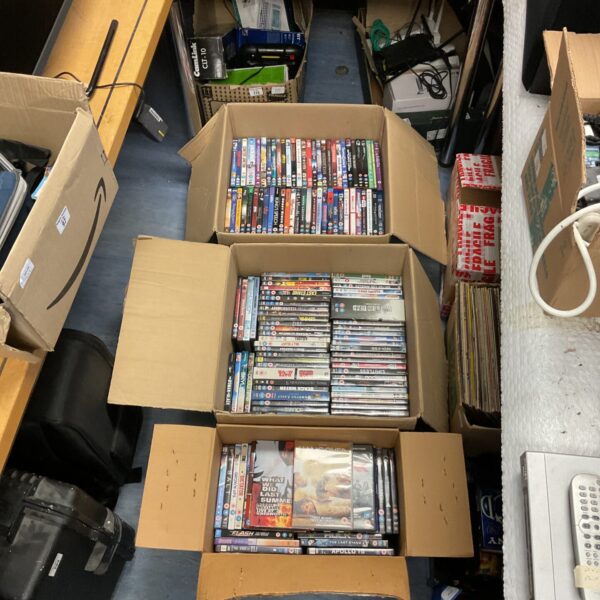 Assorted DVDs stacked in three boxes, a large movie collection.