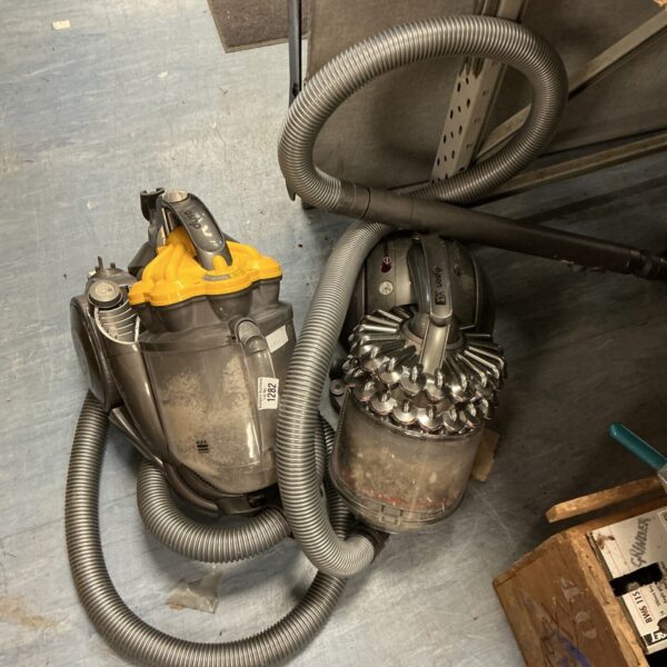 Two Dyson DC07 vacuum cleaners for repair, showing hose and body.