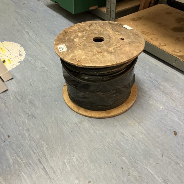 Black electrical cable roll on a wooden spool for wiring projects.