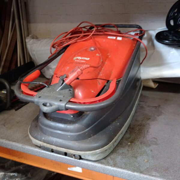 Red Flymo Turbo Compact 330 electric lawnmower for garden maintenance.