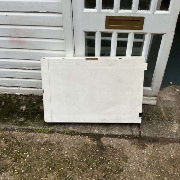 White folding plastic table outdoors, ready for use.
