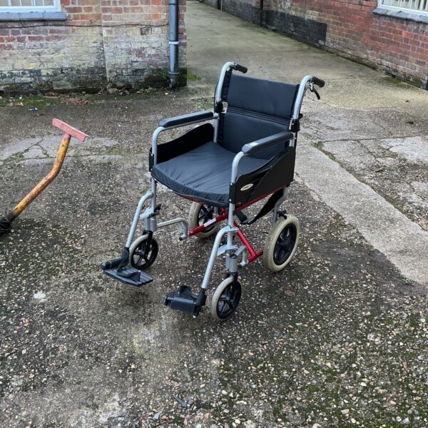 Grey folding wheelchair, a portable mobility aid.