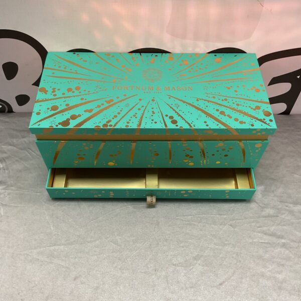 Luxury teal and gold Fortnum and Mason gift box, empty presentation packaging.
