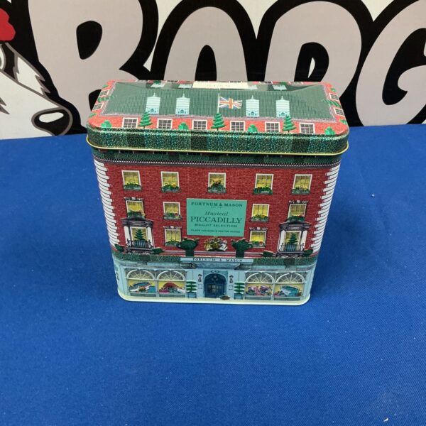 Vintage Fortnum and Mason musical Christmas tin with festive decoration.