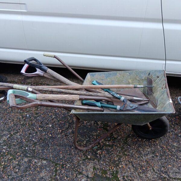Galvanised wheelbarrow and selection of garden tools for sale.