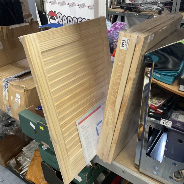 Five new Geom pine louvered doors stacked together.