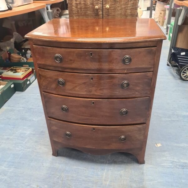 Antique Georgian chest of drawers with bow front and mahogany finish.