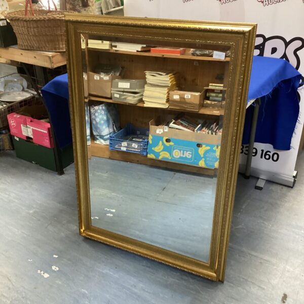 Large antique gilt framed mirror with ornate detailing.