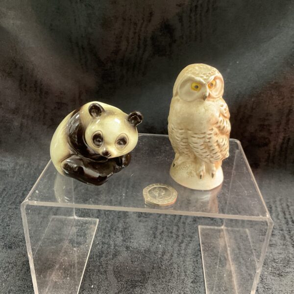 Vintage Goebel panda and owl figurines on display.