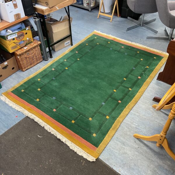 Vibrant green and orange Moroccan rug with traditional patterns.