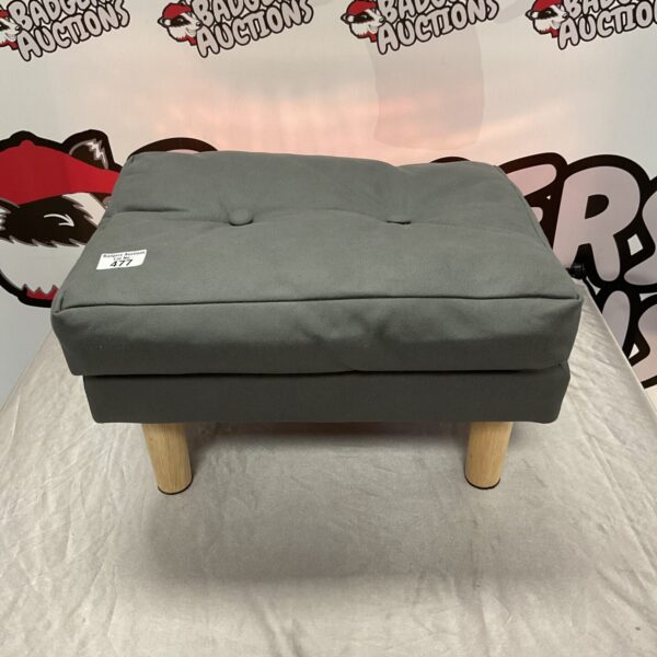 Modern grey footstool with wooden legs for living room comfort.