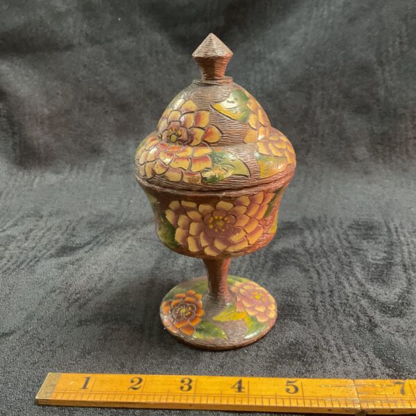 Ornate hand-carved wooden pot with colourful painted details.