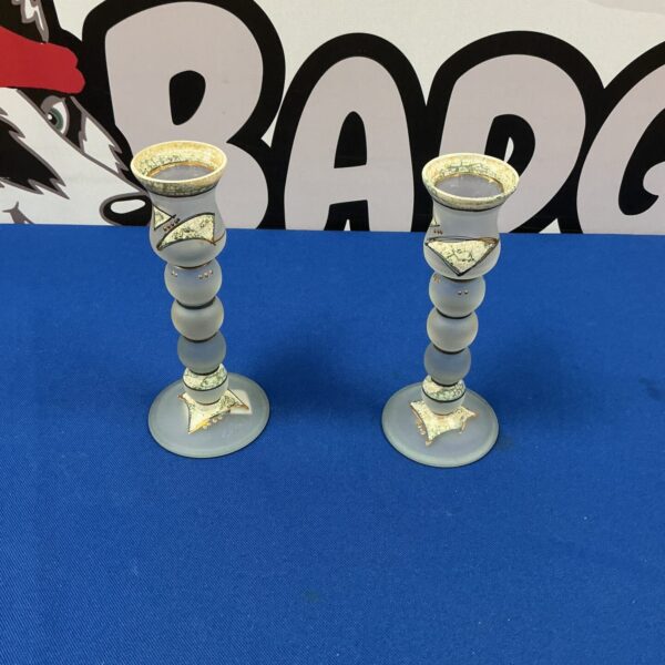 Two handpainted glass candle holders with intricate designs.