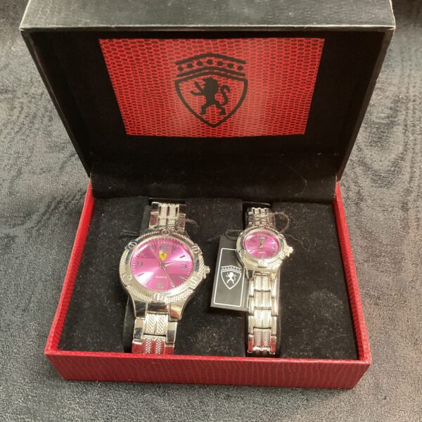 Boxed his and hers watch set with pink dials and stainless steel bands.