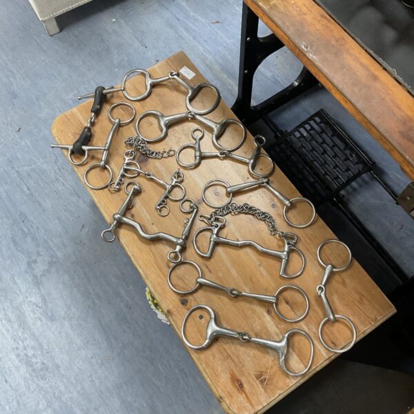 Metal horse eggbutt snaffles presented as a lot.