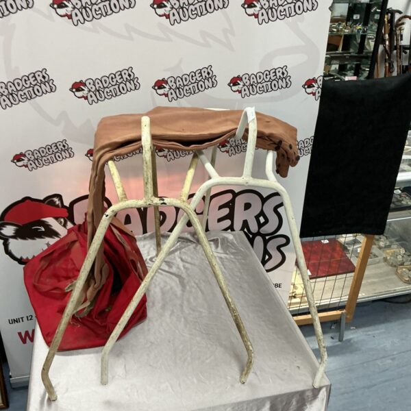 Vintage horse saddle stand with jodhpurs displayed.