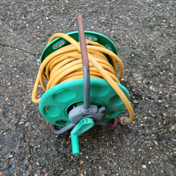 Vintage Hozelock hose reel with yellow hose wound on it.