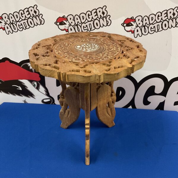 Intricately carved Indian folding table with floral designs.
