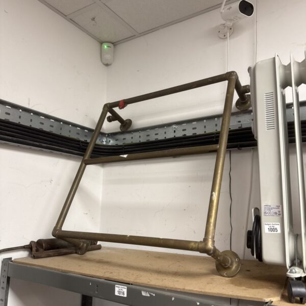 Metal industrial towel rail for bathroom storage.
