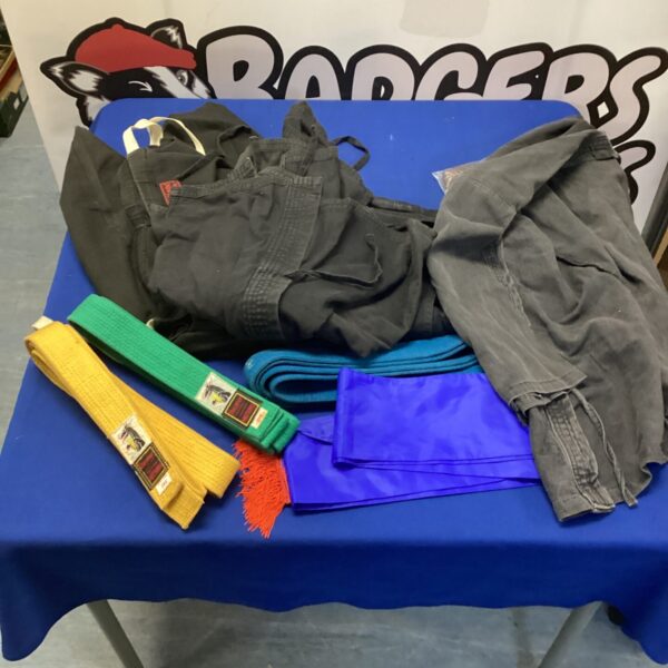 A lot of jujitsu clothing and belts for martial arts training.
