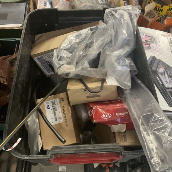 Assorted Kia and Hyundai car parts in a cardboard box.