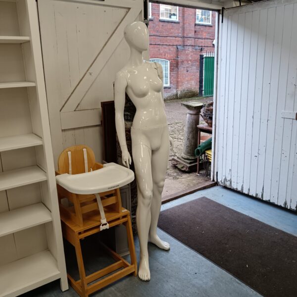 Full size lady mannequin in a doorway setting.