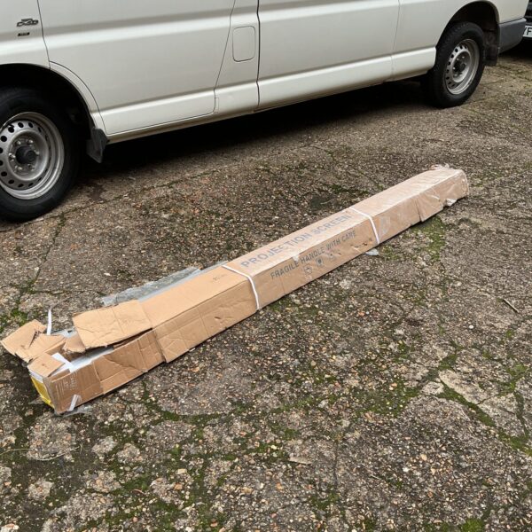 Large roll-up projector screen in a storage space.