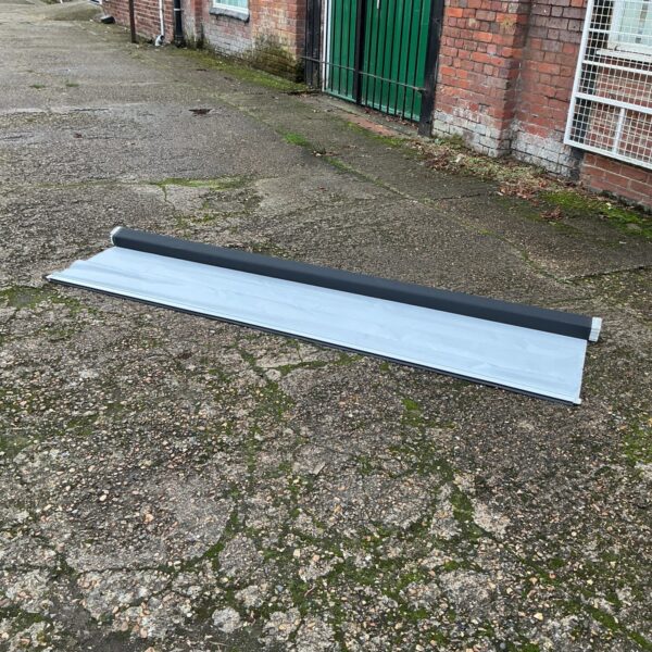 Rolled up large projector screen for home theatre viewing.