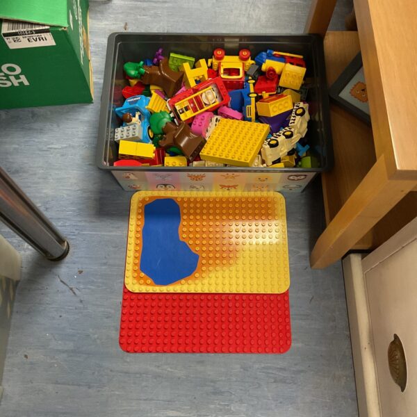 Mixed Lego Duplo blocks in a storage container, colourful building toys.