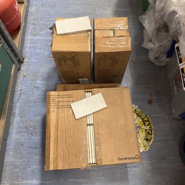 Four boxes of light grey ceramic wall tiles for home renovation.