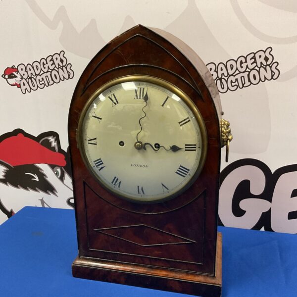 Antique mahogany bracket clock with lion head handles and cream dial.