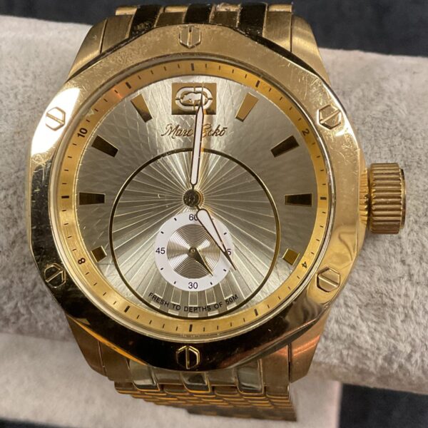 Gold-tone Marc Ecko wristwatch with detailed dial and bracelet.