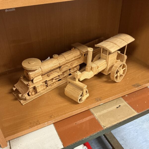 Intricate matchstick model of a steam train and road roller.