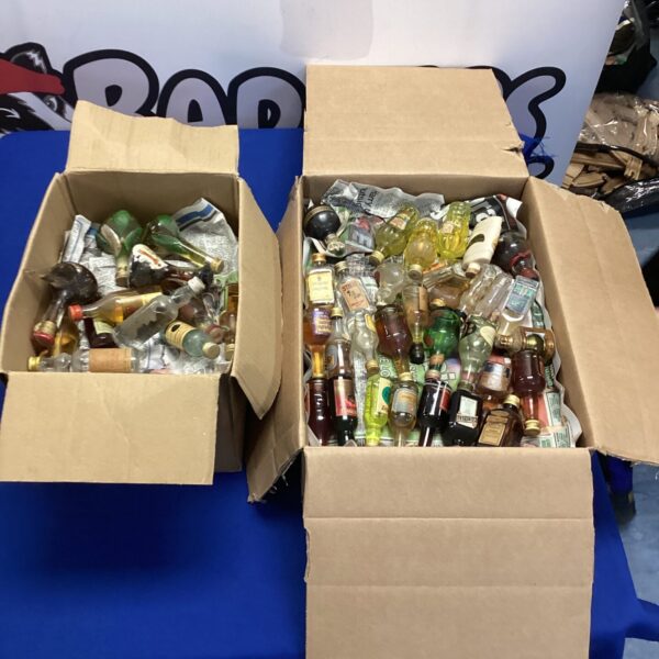 Two boxes filled with miniature alcohol bottles for collectors.