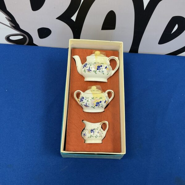 Delicate miniature Coalport tea set with floral design.
