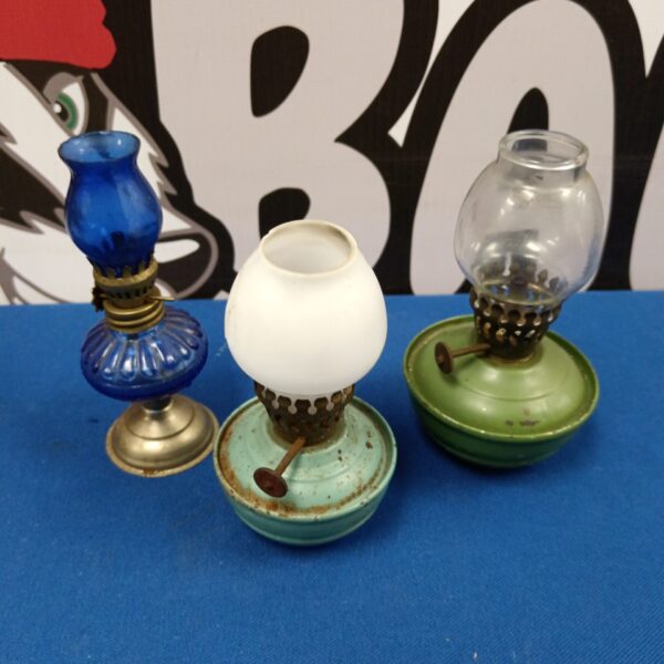 Vintage miniature oil lamps in blue, gold, and green, antique lighting.