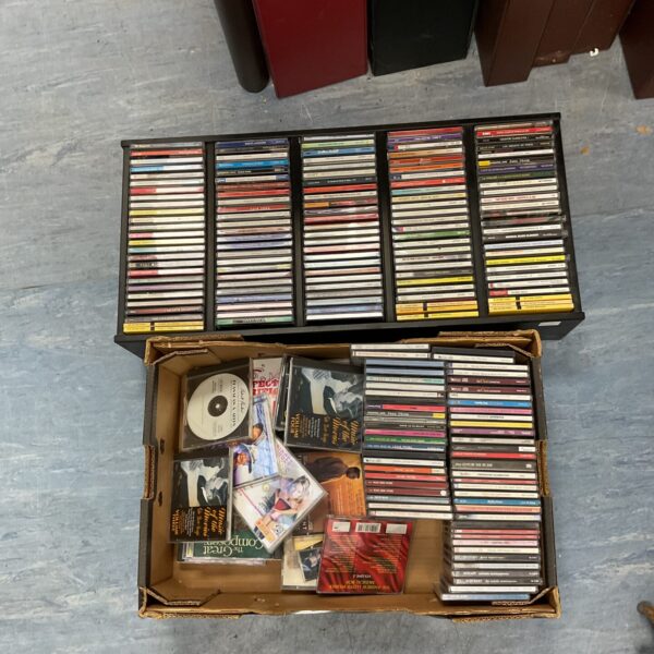 Assorted music CDs in a cardboard box, mixed CD lot.