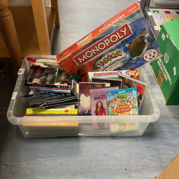 Overview of a mixed lot of games and DVDs, including Monopoly and Pokemon.