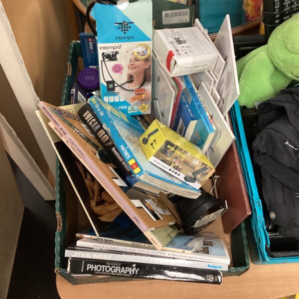 Mixed lot of books and electronics including a wireless speaker.